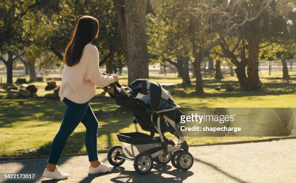 fitness, mother and walking with baby stroller with a woman enjoying fresh air at a family park while pushing carriage. adoption and motherhood while walking for fun, exercise and wellness in nature - baby pram in the park stock pictures, royalty-free photos & images