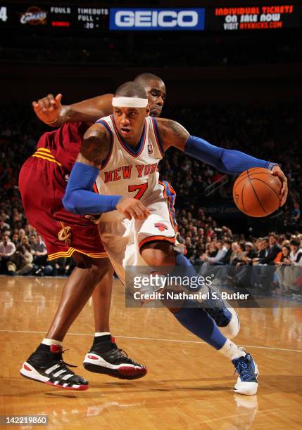 Carmelo Anthony of the New York Knicks drives to the basket around Antawn Jamison of the Cleveland Cavaliers during the game on March 31, 2012 at...