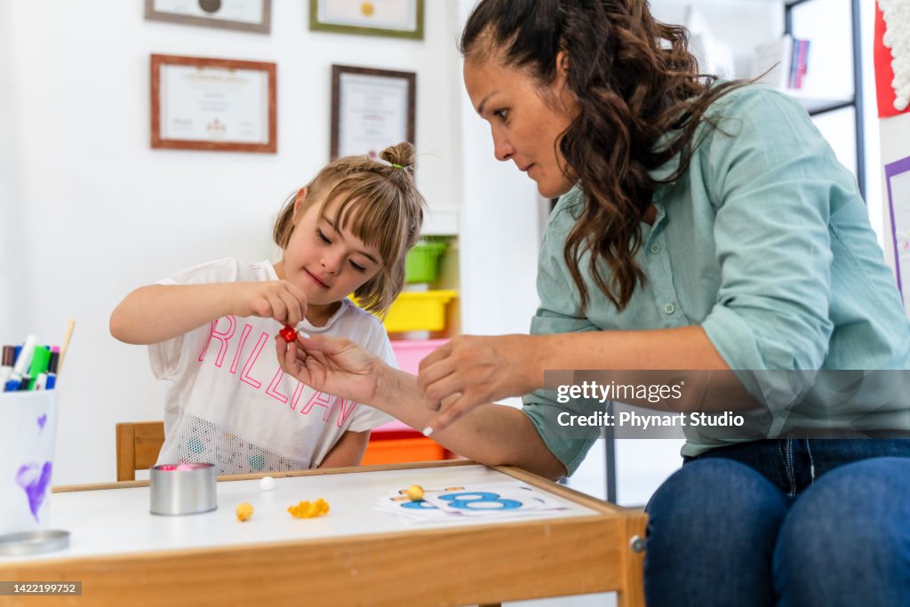 Disabled pupil and her teacher doing math