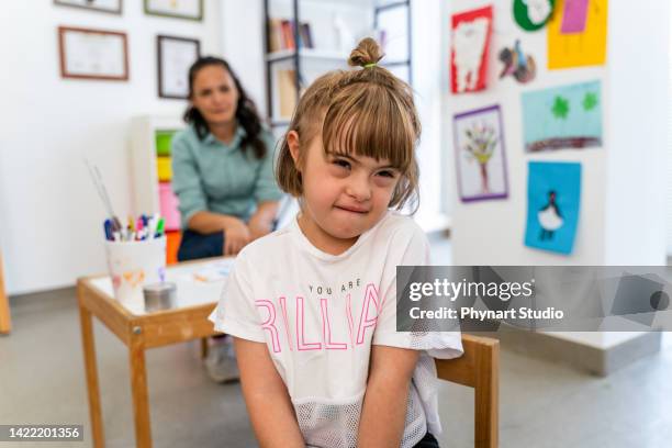 a little girl sitting on the chair infront of the desk feeling sad and angry. child loneliness, autism awareness, traumatic, the problem of child development, sadness and fearful. - sad kid in kindergarten stock pictures, royalty-free photos & images