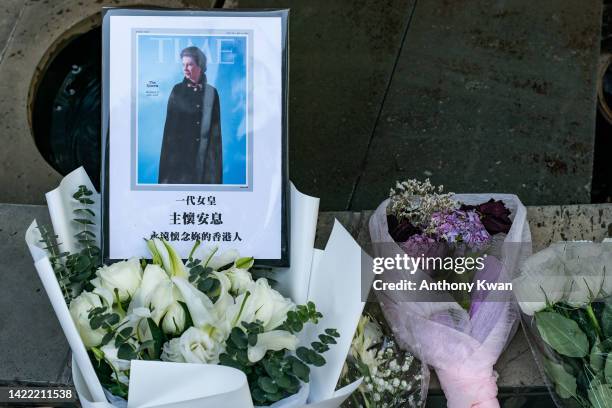 Flower bouquets and a photograph is left for Britain's Queen Elizabeth II outside the British Consulate General Hong Kong on September 09, 2022 in...