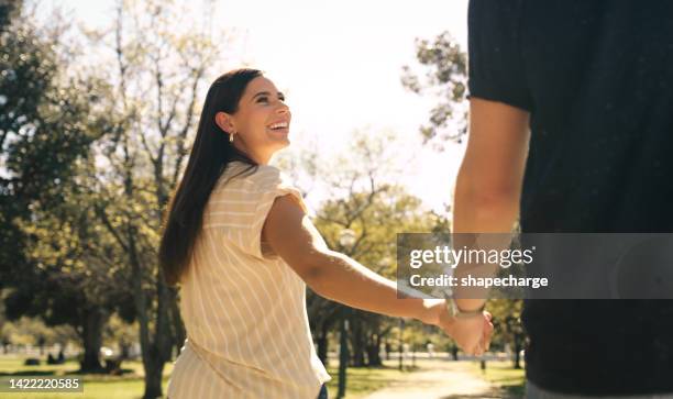 happy, love and relax mindset of a woman holding hands with her boyfriend in a outdoor park. couple spending time together in nature with a smile feeling happiness and romance in the sun in summer - couple holding hands stock pictures, royalty-free photos & images