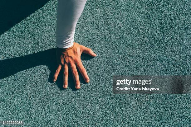 white man hand on the concrete sports ground floor of blue colors - floor gymnastics bildbanksfoton och bilder