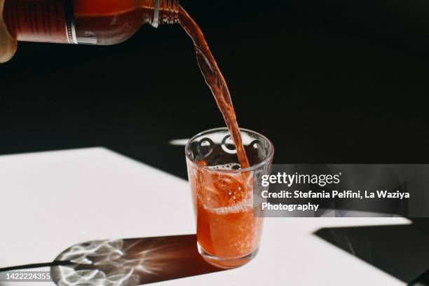 kombucha pouring in a drinking glass - fruchtsaft stock-fotos und bilder