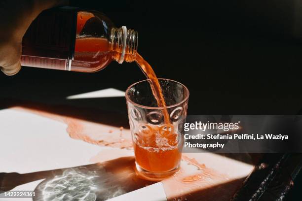 juice spilling on white surface - kombucha stockfoto's en -beelden
