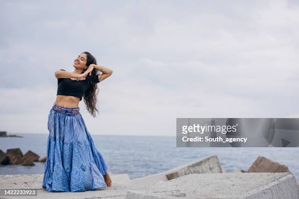 beautiful indian girl traditional dancing on the beach - beach fashion show stock pictures, royalty-free photos & images
