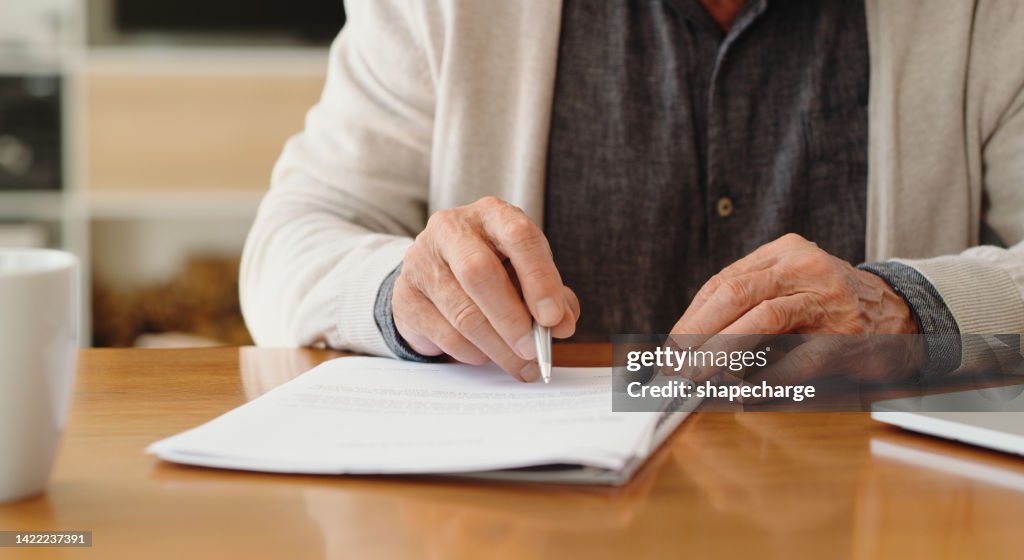 Hands of senior retirement woman writing a finance savings budget plan on paper or legal trust fund for after her funeral. Elderly person apply for pension or government financial support and help