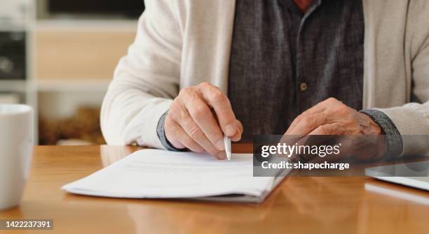 hands of senior retirement woman writing a finance savings budget plan on paper or legal trust fund for after her funeral. elderly person apply for pension or government financial support and help - funeral 個照片及圖片檔