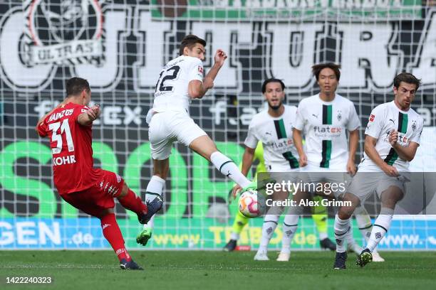 Florian Neuhaus of Moenchengladbach tries to block a shot from Dominik Kohr of Mainz during the Bundesliga match between Borussia Mönchengladbach and...