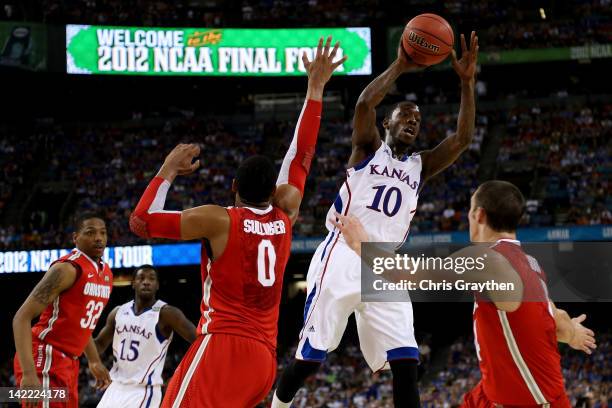 Tyshawn Taylor of the Kansas Jayhawks looks to pass the ball over Jared Sullinger and Aaron Craft of the Ohio State Buckeyes in the first half during...