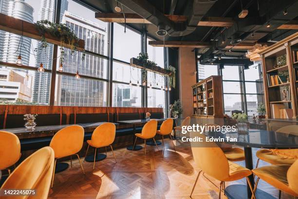 cozy restaurant interior design with yellow chair - café cultuur stockfoto's en -beelden