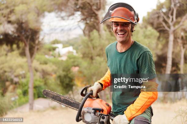 portrait of a lumberjack holding a chainsaw. - houthakker stockfoto's en -beelden