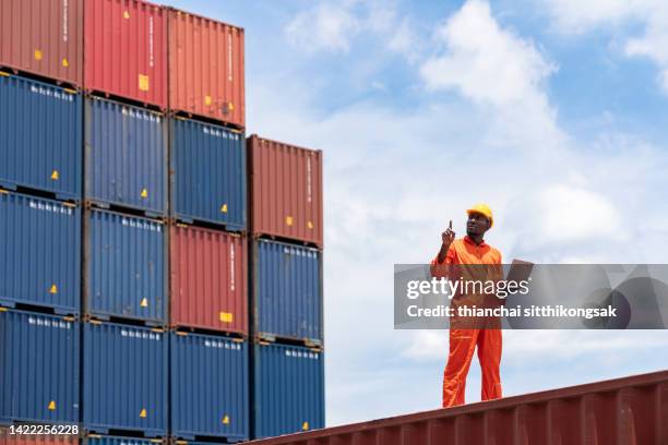 low view of  black african engineer using laptop checking shipping cargo freights. - africa immigration stock pictures, royalty-free photos & images