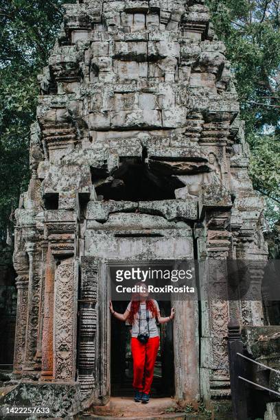 woman standing in the doorway of the ancient temple of ankor wat in cambodia - angkor wat stock pictures, royalty-free photos & images