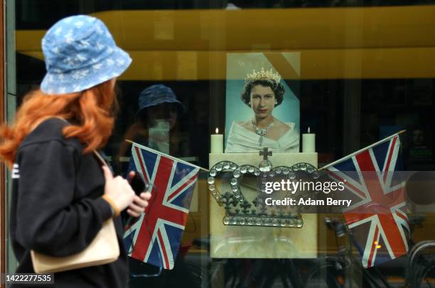 Pedestrian passes an image of Queen Elizabeth II the day after her death, on September 09, 2022 in Berlin, Germany. Queen Elizabeth II, the UK's...