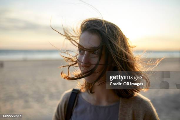portrait of woman with tousled hair on the beach - exposto pelo vento imagens e fotografias de stock