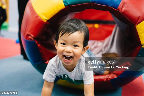 young boy having best fun time ever at playground joyfully - alleen jongens stockfoto's en -beelden