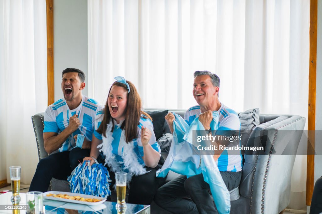 Die Fußballfans der argentinischen Mannschaft sitzen im Wohnzimmer ihres Hauses im Trikot der Mannschaft und verfolgen das Spiel Minute für Minute mit großer Leidenschaft.