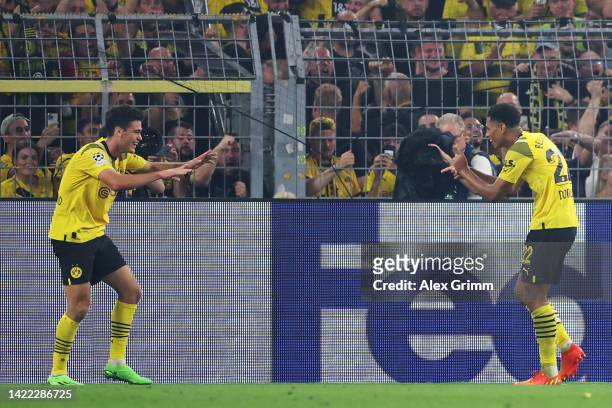 Jude Bellingham of Borussia Dortmund celebrates their team's third goal with teammate Giovanni Reyna during the UEFA Champions League group G match...