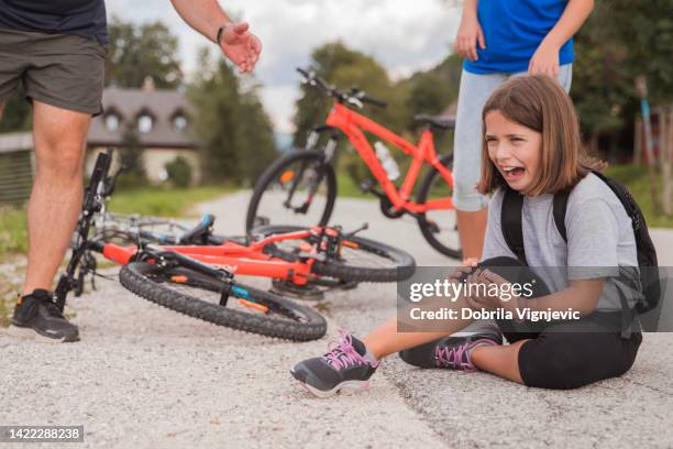 girl shouting in pain after falling from bicycle - sports pain bildbanksfoton och bilder