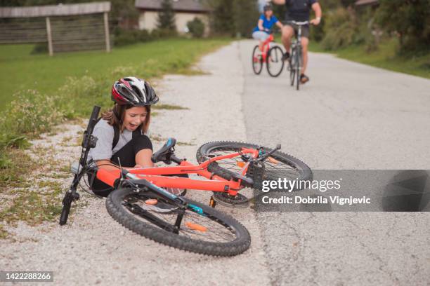 girl sitting by bicycle after falling and screaming in pain - girl lying down stock pictures, royalty-free photos & images