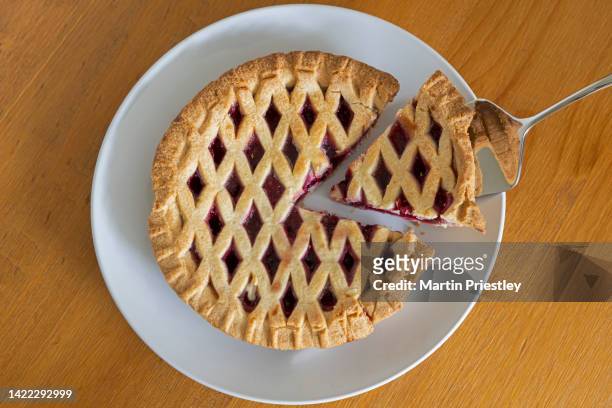 still life photograph of a cherry pie, with a slice being taken. - cherry pie stock-fotos und bilder