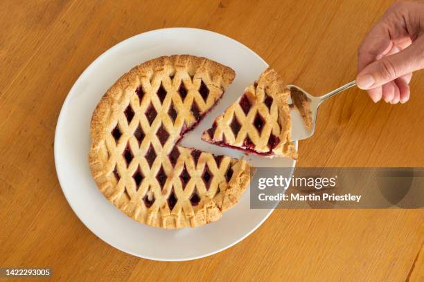 still life photograph of a cherry pie, with a slice being taken. - cake slices stock pictures, royalty-free photos & images