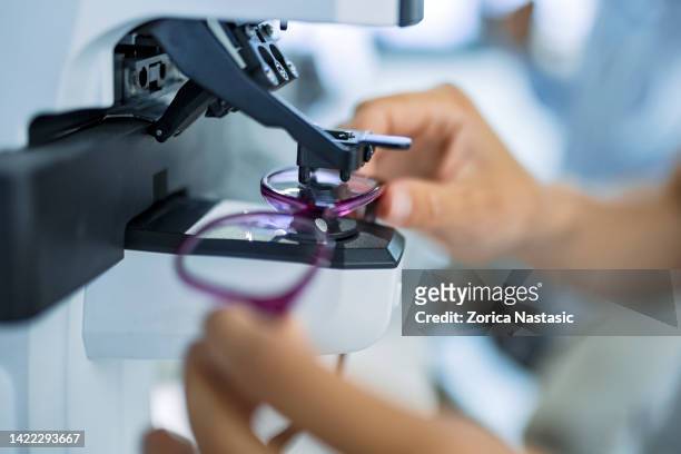 persona irreconocible midiendo vidrio en gafas - optical instrument fotografías e imágenes de stock