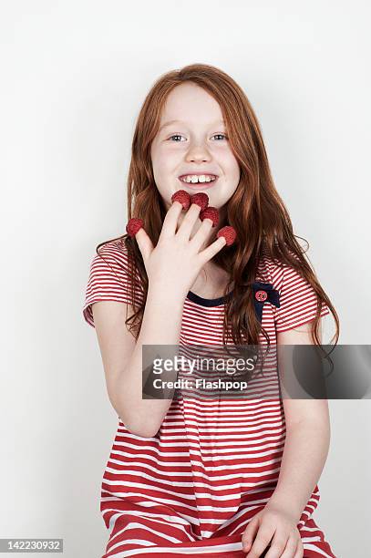 portrait of girl eating fruit - raspberry foto e immagini stock