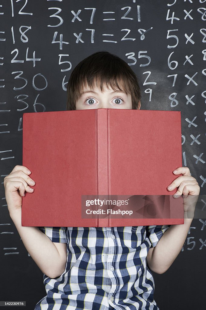 Portrait of boy holding school book