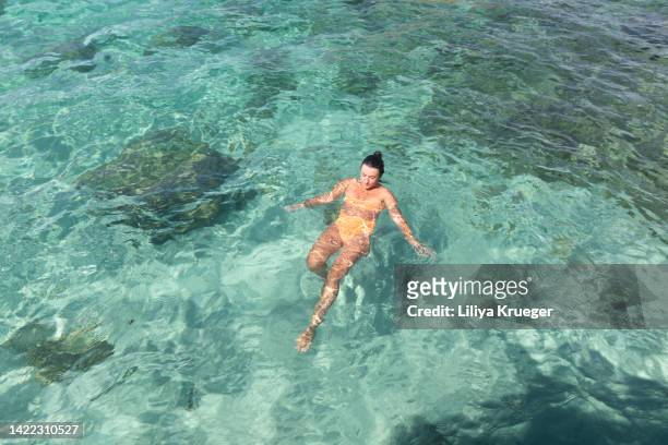 happy woman swims in the transparent clear sea in sardinia. - white bay stock pictures, royalty-free photos & images