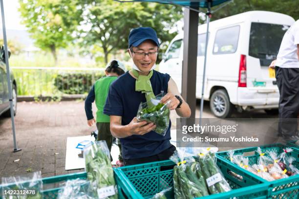 organic vegetable farmers' market and people on a summer saturday - 手ぬぐい ストックフォトと画像
