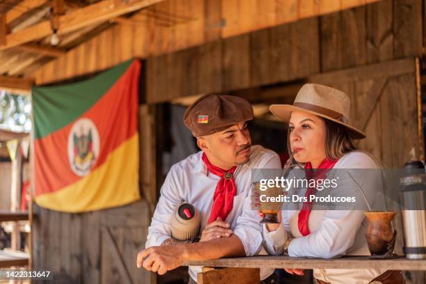 gaucho couple drinking chimarrao at the farroupilha camp - gaucho stock pictures, royalty-free photos & images