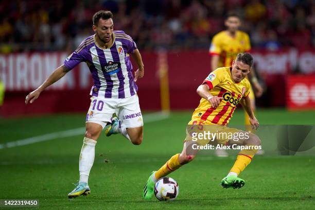 Manu Vallejo of Girona FC is challenged by Oscar Plano of Real Valladolid CF during the LaLiga Santander match between Girona FC and Real Valladolid...