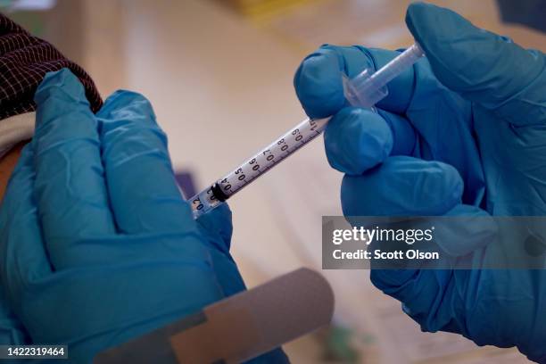 Pharmacist gives a COVID-19 vaccine booster shot during an event hosted by the Chicago Department of Public Health at the Southwest Senior Center on...