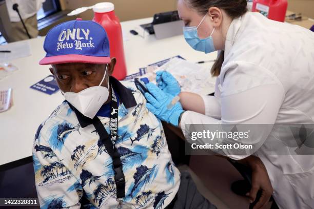 Sylvester Fisher gets a COVID-19 vaccine booster shot from pharmacist Patricia Pernal during an event hosted by the Chicago Department of Public...