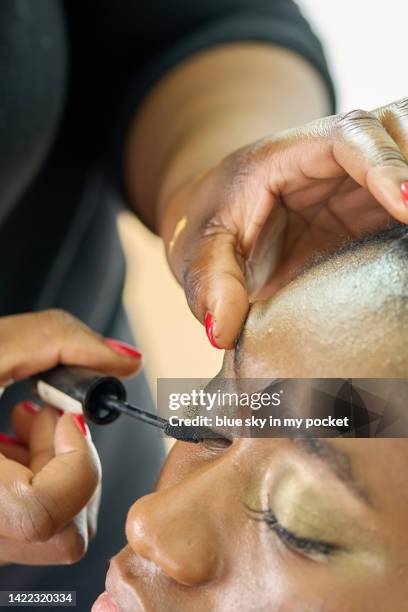 a young woman having mascara make-up applied to her flash eyelashes - flash eyelashes stock pictures, royalty-free photos & images