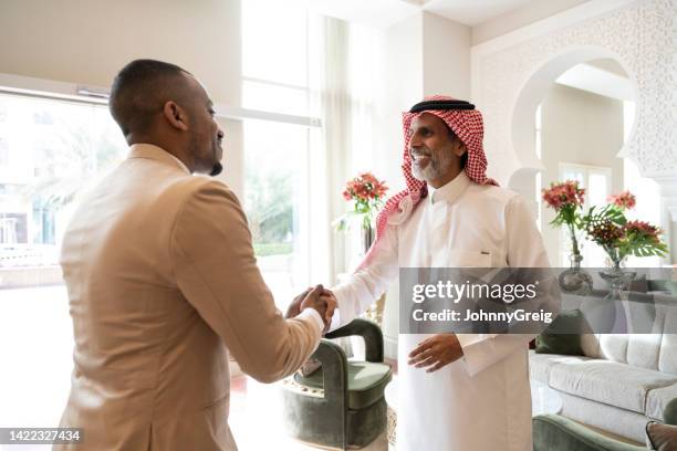 cordial handshake between businessmen in riyadh hotel lobby - free trade agreement stockfoto's en -beelden