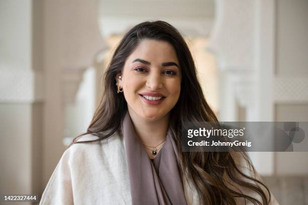 indoor-porträt einer fröhlichen geschäftsfrau aus dem nahen osten - portrait frau arabisch frontal stock-fotos und bilder