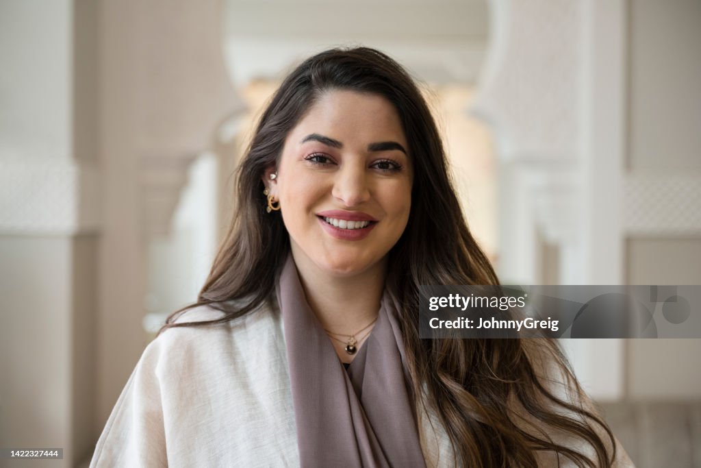 Indoor portrait of cheerful Middle Eastern businesswoman