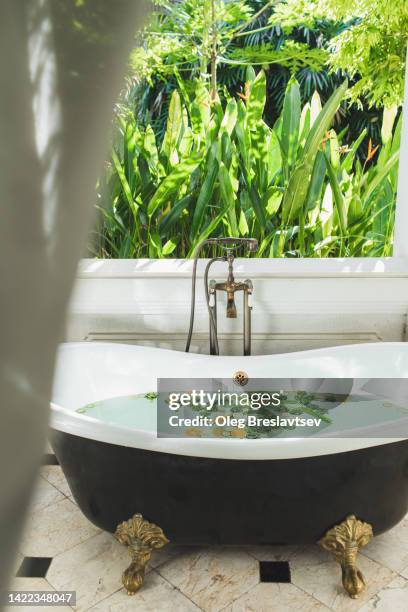 beauty spa treatment in asian style. outside bath tub with view of tropical garden - bali spa stock pictures, royalty-free photos & images