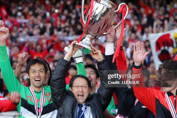 Toyota Motor Co president Akio Toyoda lifts the trophy following the Fuji Xerox Super Cup between Nagoya Grampus and Kashima Antlers at Nissan...