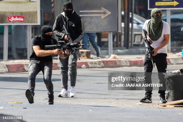 Palestinian armed militants take up position during a confrontation with Israeli army in the occupied West Bank city of Jenin on July 3, 2023. The...