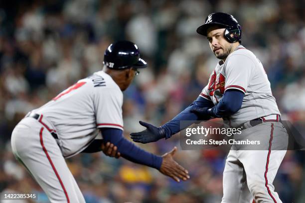 Third base coach Ron Washington and Travis d'Arnaud of the Atlanta Braves celebrates a home run by d'Arnaudduring the fifth inning against the...