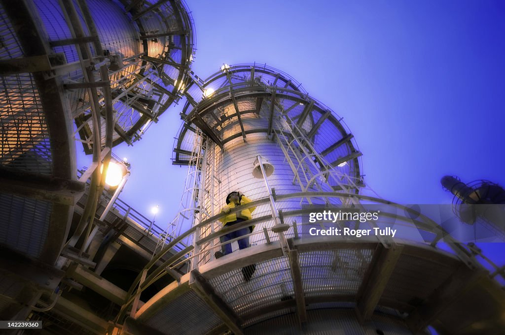 Man on oil refinery distillation tower