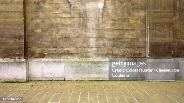 weathered brown and gray stone wall with cobblestone sidewalk in paris, france - church color light paris stockfoto's en -beelden