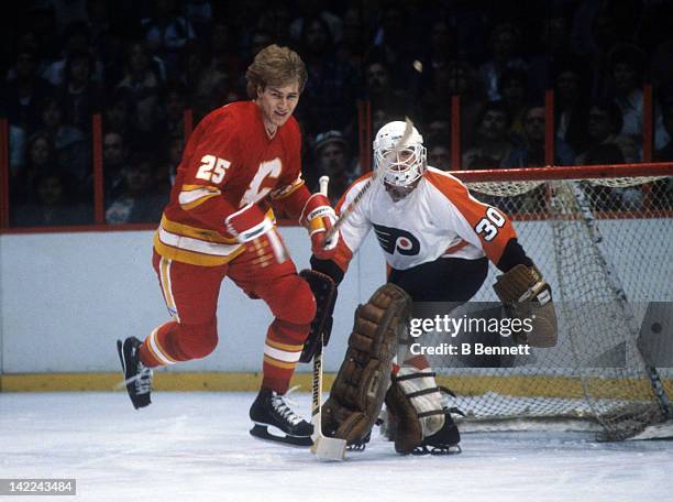 Willi Plett of the Calgary Flames skates in front of goalie Rick St. Croix of the Philadelphia Flyers circa 1981 at the Spectrum in Philadelphia,...