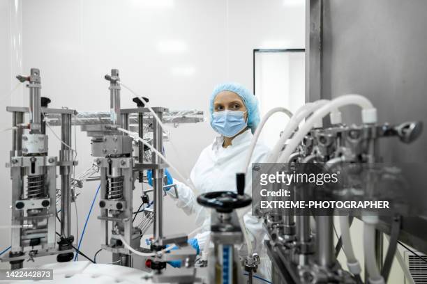 fully equipped technician in protective workwear seen in a pharmaceutical laboratory - drug manufacturing stock pictures, royalty-free photos & images