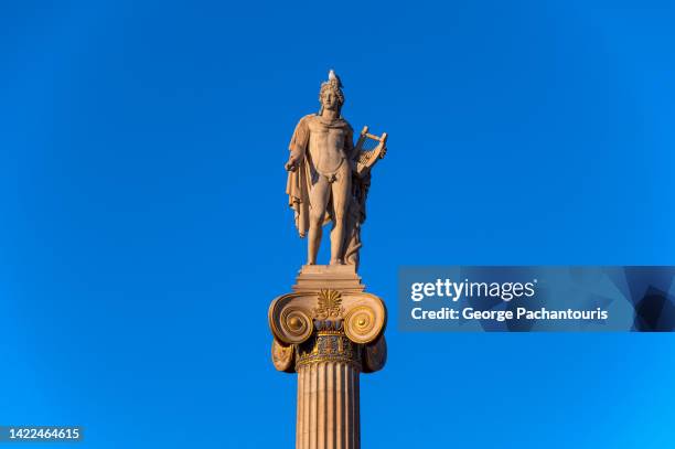statue of god apollo and the clear blue sky - greek god apollo stock-fotos und bilder