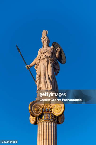 statue of goddess athena ιand the clear blue sky - griechische göttin stock-fotos und bilder
